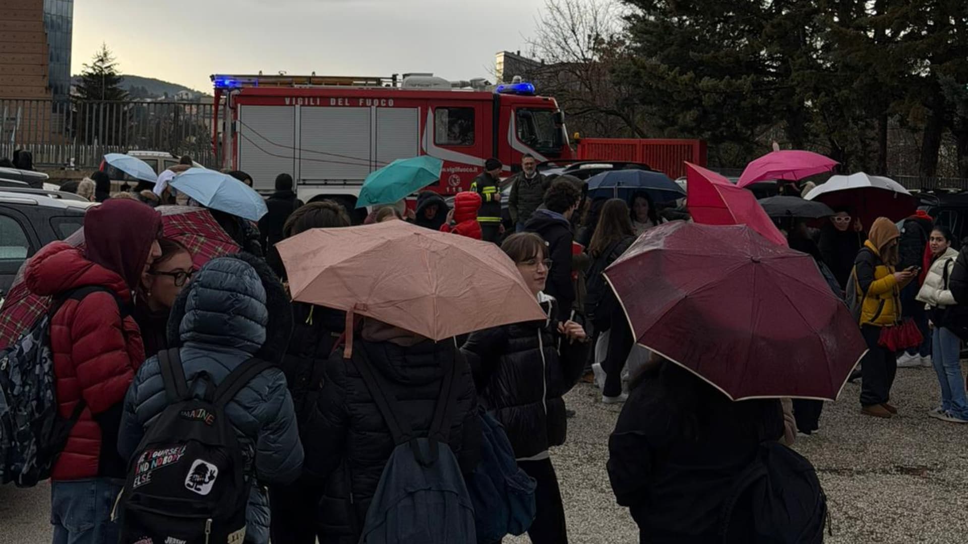 Studenti fuori dalla scuola e automezzo dei vigili del fuoco
